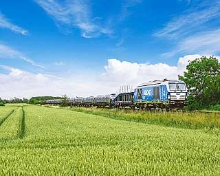 The blue AUTOZUG Sylt travels fully loaded through the North Frisian landscape.