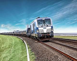 Der blaue AUTOZUG Sylt fährt über den Damm nach Sylt