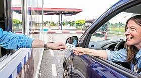 Check-in beim blauen AUTOZUG Sylt am Terminal in Niebüll. Eine Frau zeigt ihre Stammkundenkarte vor.
