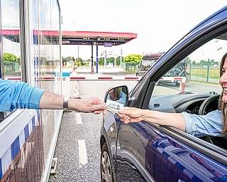 Check-in beim blauen AUTOZUG Sylt am Terminal in Niebüll. Eine Frau zeigt ihre Stammkundenkarte vor.