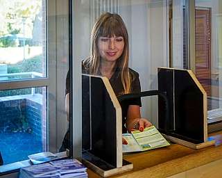 An employee of the RDC Deutschland Gruppe is showing a flyer in the RDC Kundencenter Niebüll.