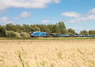 Der blaue AUTOZUG Sylt - Fahrt an herbstlichem Feld