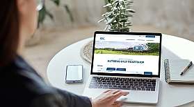Blick über die Schulter einer Frau auf einen Laptopbildschirm, auf dem der Webshop vom blauen AUTOZUG geöffnet ist.