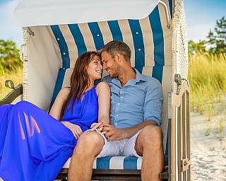 Ein Päärchen sitzt auf Sylt in einem Strandkorb am Strand.